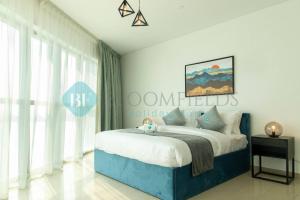 a bedroom with a bed with a blue bed frame at Relaxing 2 Bedrooms In Rak in Abu Dhabi