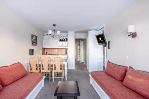 un soggiorno con divano rosso e tavolo di Résidence Quartier Falaise - maeva Home - Appartement 2 Pièces 6 Personnes 854 ad Avoriaz