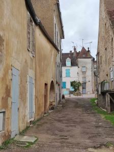 an empty alley in an old town with buildings at La Loupière in Avallon