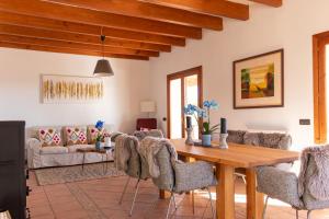 ein Wohnzimmer mit einem Holztisch und Stühlen in der Unterkunft Natursteinfinca mit Meerblick & Pool in Porto Cristo
