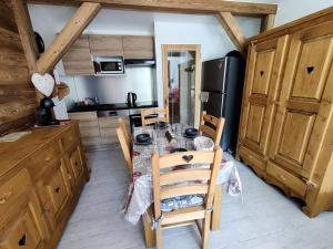 una cucina con tavolo, sedie e frigorifero di Résidence Saint Roch - Agréable Studio 4 Personnes à proximité des pistes+Coin cabine MAE-8044 a Puy-Saint-Vincent