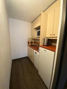a small kitchen with white cabinets and a counter top at Résidence Les Ravines - maeva Home - Studio 4 Personnes - Sélection 524 in Les Allues