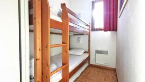 a room with two bunk beds and a window at Résidence Les Gentianes - Appartements pour 6 Personnes 204 in Narreyroux