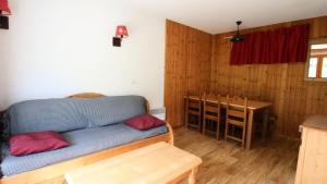 a living room with a blue couch and a table at Résidence Dame Blanche - 2 Pièces pour 6 Personnes 374 in Narreyroux