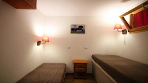um quarto com duas camas e duas luzes na parede em Résidence Dame Blanche - 2 Pièces pour 6 Personnes 384 em Narreyroux