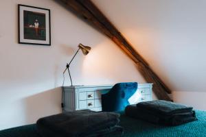 - une chambre avec un lit, une commode et une lampe dans l'établissement Le Grenier d’Anatole : Parking / Haut Standing, à Châteauroux