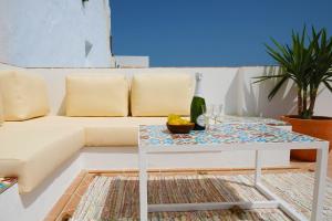 un soggiorno con divano bianco e tavolo di Vejerísimo Casa Boutique a Vejer de la Frontera