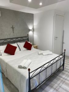 a bedroom with a large white bed with red pillows at Royal House in Catania