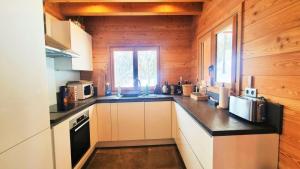 a kitchen with white cabinets and a black counter top at Chalet Piganiol-puy-saint-vincent - Chalets 684 in Les Prés