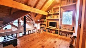 a large room with wooden ceilings and a tv and book shelves at Chalet Piganiol-puy-saint-vincent - Chalets 684 in Les Prés