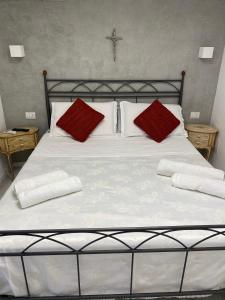 a large bed with two red pillows on it at Royal House in Catania