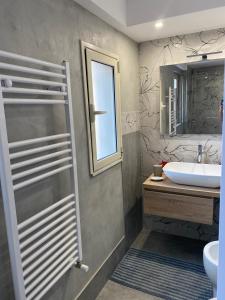 a bathroom with a sink and a toilet and a mirror at Royal House in Catania