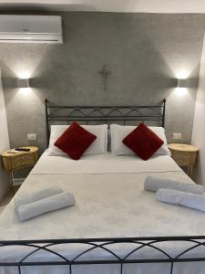 a large bed with two red pillows on it at Royal House in Catania