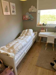 a bed in a room with a desk and a window at Spacious house near city centre - WSC 2025! in Trondheim