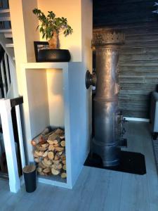 una chimenea en una habitación con una pila de troncos en Spacious house near city centre, en Trondheim