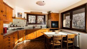 uma cozinha com armários de madeira e uma mesa com cadeiras em Chalet Belvedere-vallouise - Chalets pour 9 Personnes 424 em Vallouise