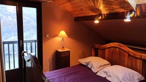 a bedroom with a bed with purple sheets and a window at Chalet Belvedere-vallouise - Chalet avec vue sur Vallouise 9 personnes MAE-2424 in Vallouise