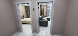 a view of a room with a bed and a mirror at Отличная квартира со всеми удобствами in Kokshetau
