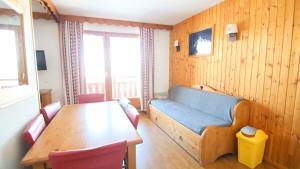 un soggiorno con un tavolo e un divano blu di Résidence Parc Aux Etoiles - PARC AUX ETOILES -C314- AVEC PISCINE ET SAUNA-Appt 4/6 p MAE-8404 a Narreyroux
