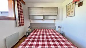 a bed in a room with a plaid blanket on it at Résidence Dame Blanche - 2 Pièces pour 6 Personnes 634 in Narreyroux