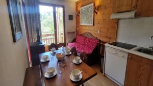 eine Küche mit einem Tisch und einem Esszimmer in der Unterkunft Résidence Le Palatin - Appartements pour 6 Personnes 484 in Pelvoux