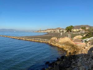 een strand met een rotsachtige kustlijn en de oceaan bij Apartamento La cala 2 in Cala del Moral