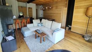 a living room with a white couch and a table at Chalet - Chalets pour 13 Personnes 594 in Puy-Saint-Vincent