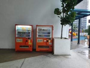 dos máquinas de soda naranja sentadas una al lado de la otra en Imperial suites@Reizz residence, en Kuala Lumpur