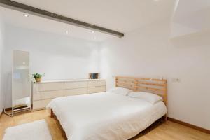 ein weißes Schlafzimmer mit einem Bett und einem Fenster in der Unterkunft Calle Suevia 13 in A Coruña