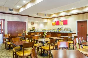 ein Restaurant mit Tischen und Stühlen und einer Theke in der Unterkunft Comfort Suites in Twinsburg