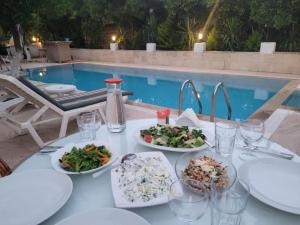 a table with plates of food next to a pool at Felicity Hotel & Bungalows in Kemer