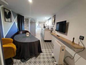 een kleine woonkamer met een tafel en een keuken bij Studio calme et proche de Rennes in Vezin-le-Coquet