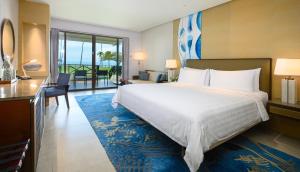 a hotel room with a large bed and a desk at Shangri-La Tanjung Aru, Kota Kinabalu in Kota Kinabalu