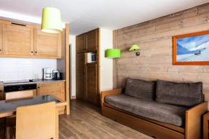 a living room with a couch and a kitchen at Résidence Le Christiana - maeva Home - Appartement 2 Pièces 5 Personnes - Sélection MAE-3814 in Saint-Bon-Tarentaise