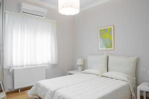 a white bedroom with a bed and a window at Amazing location - 2 min from Acropolis in Athens