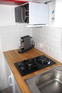 a kitchen with a stove and a sink and a microwave at Lovely studio in Paris in Paris