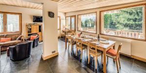 a dining room with a table and some windows at Chalet Les Lauzes - Chalets pour 10 Personnes MAE-3288 in Champagny-en-Vanoise
