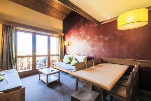 Zimmer mit einem Tisch, einem Sofa und einem Fenster in der Unterkunft Quartier La Forêt - maeva Home - Appartement 3 pièces 7 personnes - Sélec 834 in Valmorel