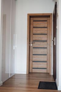 uma porta de madeira num quarto com um tapete em Apartman New York em Podhájska