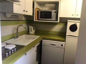 a small kitchen with a sink and a microwave at Résidence Marches - Les Marches 25 - 3 pièces en duplex, vue pistes, classé 3 étoiles MAE-4974 in Valmorel