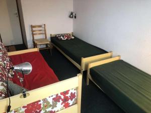 a room with two beds and a chair in it at Résidence Marches - Les Marches 25 - 3 pièces en duplex, vue pistes, classé 3 étoiles MAE-4974 in Valmorel +4 photos