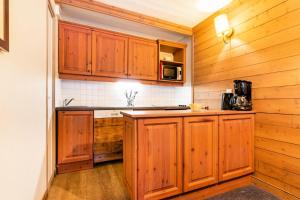 a kitchen with wooden cabinets and a counter top at Quartier La Forêt - maeva Home - Appartement 2 pièces 5 personnes - Sélection MAE-3904 in Valmorel