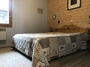 a bedroom with a bed with a quilt on it at Résidence Marches - Les Marches 24 - Joli 2 pièces en bordure de pistes MAE-5034 in Valmorel