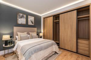 sypialnia z łóżkiem typu king-size i drewnianymi szafkami w obiekcie MH Apartments Soho Madrid w Madrycie