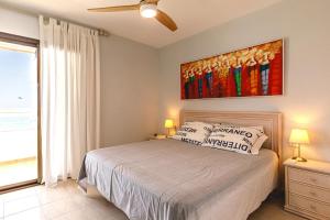 ein Schlafzimmer mit einem Bett und einem Gemälde an der Wand in der Unterkunft Cap Negret Altea Mar in Altea + 9 Fotos