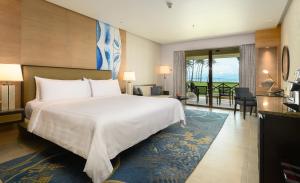 a bedroom with a large bed and a living room at Shangri-La Tanjung Aru, Kota Kinabalu in Kota Kinabalu