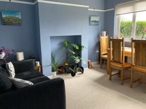 a living room with a couch and a dining room at Cosy at Cumberland - Double room with shared bathroom in Dundonald