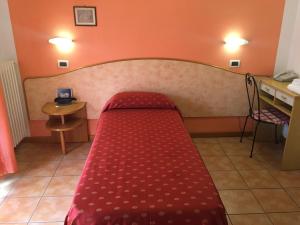 Hotel Magda في Novafeltria: غرفة نوم صغيرة مع سرير احمر في غرفة