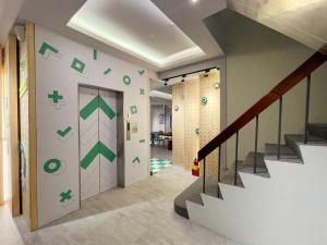 a hallway with a staircase with green arrows on the wall at together hotel-Hualien Zhongshan in Hualien City