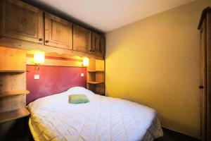 a bedroom with a bed with a green towel on it at Quartier La Forêt - maeva Home - Appartement 2 pièces 6 personnes + coin cabine - Sélection MAE-5444 in Valmorel